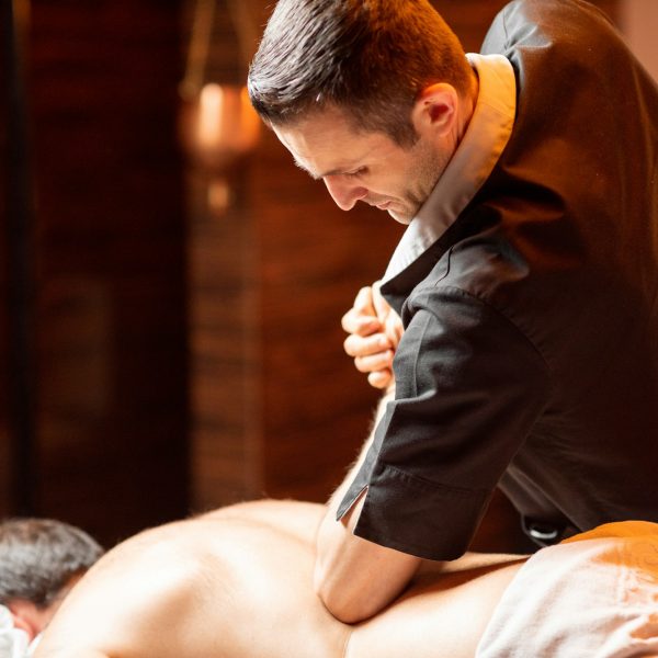 Masseur doing a deep massage to a male client